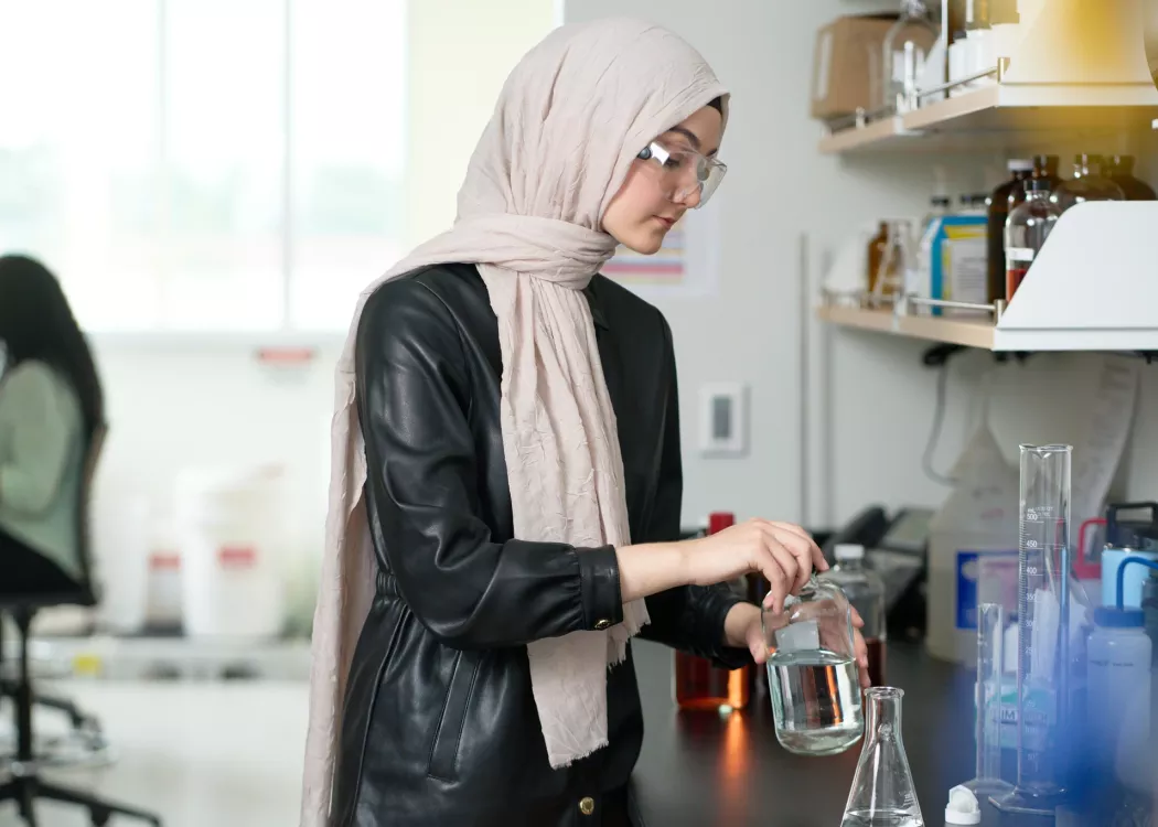 Female student performs chemistry experiment in a lab